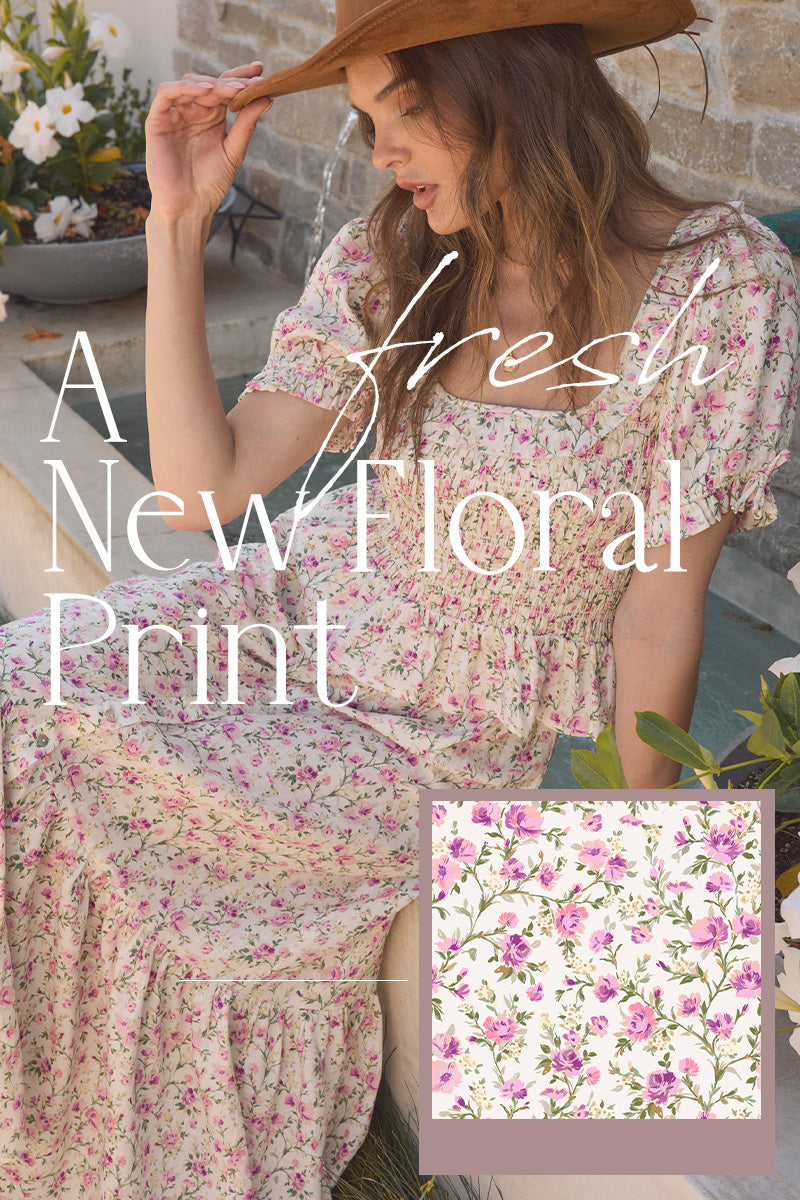 Woman wearing a floral dress with a close-up of the fabric pattern on a stone wall background