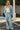 A full body front view of a woman wearing the Saltwater Luxe in front of a pool