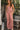 Full body front view of a woman wearing the Saltwater Luxe Adair Pant in Coffee in a garden