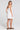 Back view of a woman wearing the Saltwater Luxe Adelina Mini Dress in White on a neutral background