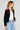 Side angle view of a woman wearing the Saltwater Luxe Aden Black Sweater on a neutral background