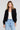 Front view of a woman wearing the Saltwater Luxe Aden Black Sweater on a neutral background