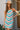 Front view of a woman wearing the Saltwater Luxe Camdyn Mini Dress in front of a house