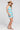 Side angle view of a woman wearing the Saltwater Luxe Camdyn Mini Dress on a neutral background