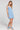 Side angle view of a woman wearing the Saltwater Luxe Carson Mini Dress in Dusty Blue on a neutral background