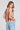 Back view of a woman wearing the Saltwater Luxe Chelsee Natural Top on a neutral background