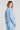 Back view of a woman wearing the Saltwater Luxe Delmar Jacket in Dusty Blue on a neutral background