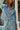 Front view of a woman wearing the Saltwater Luxe Delmar Jacket in Dusty Blue in a garden