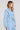Side angle view of a woman wearing the Saltwater Luxe Delmar Jacket in Dusty Blue on a neutral background