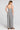 Back view of a woman wearing the Saltwater Luxe Dorit Jumper on a neutral background