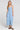 Front view of a woman wearing the Saltwater Luxe Elison Dusty Blue Midi Dress on a neutral background