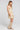 Side angle view of a woman wearing the Saltwater Luxe Gracee Mini Dress in Fawn on a neutral background