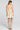 Back view of a woman wearing the Saltwater Luxe Gracee Mini Dress in Fawn on a neutral background