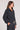 Side angle view of a woman wearing the Saltwater Luxe Half Zip Black Seam Pullover on a neutral background