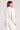 Back view of a woman wearing the Saltwater Luxe  Half Zip Ecru Seam Pullover on a neutral background