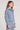 Side angle view of a woman wearing the Saltwater Luxe Half Zip Worn Blue Seam Pullover on a neutral background