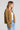 Side angle view of a woman wearing the Saltwater Luxe Havenn Fawn Sweater on a neutral background