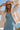 Font view of a woman wearing the Saltwater Luxe Havenn Natural Sweater on the beach