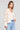 Side angle view of a woman wearing the Saltwater Luxe Havenn Natural Sweater on a neutral background