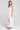 Side angle view of a woman wearing the Saltwater Luxe Hayley Midi Dress on a neutral background