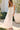 Front view of a woman wearing the Saltwater Luxe Hayley Midi Dress in a garden