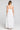 Back view of a woman wearing the Saltwater Luxe Hayley Midi Dress on a neutral background