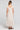 Back view of a woman wearing the Saltwater Luxe Junniper Midi Dress on a neutral background
