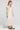 Side angle view of a woman wearing the Saltwater Luxe Junniper Midi Dress on a neutral background