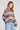 Side angle view of a woman wearing the Saltwater Luxe Kirra Dusty Blue Sweater on a neutral background