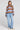 A full body front view of a woman wearing the Saltwater Luxe Kirra Dusty Blue Sweater on a neutral background