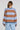 Back view of a woman wearing the Saltwater Luxe Kirra Dusty Blue Sweater on a neutral background