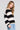 Side angle view of a woman wearing the Saltwater Luxe  Kirra Natural Sweater  on a neutral background