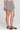Side angle view of a woman wearing the Saltwater Luxe Leto Short  on a neutral background