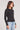 Side angle view of a woman wearing the Saltwater Luxe Long Sleeve Black Cardigan on a neutral background