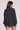 Back view of a woman wearing the Saltwater Luxe  Long Sleeve Black Pullover on a neutral background