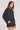 Side angle view of a woman wearing the Saltwater Luxe  Long Sleeve Black Pullover on a neutral background