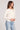 Side angle view of a woman wearing the Saltwater Luxe Long Sleeve Ecru Cardigan on a neutral background