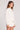 Side angle view of a woman wearing the Saltwater Luxe Long Sleeve Ecru Pullover on a neutral background