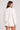 Back view of a woman wearing the Saltwater Luxe Long Sleeve Ecru Pullover on a neutral background
