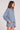 Side angle view of a woman wearing the Saltwater Luxe Long Sleeve Worn Blue Pullover on a neutral background