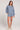 Full body front view of a woman wearing the Saltwater Luxe Long Sleeve Worn Blue Pullover on a neutral background