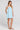 Side angle view of a woman wearing the Saltwater Luxe Lukas Mini Dress on a neutral background