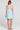 Back view of a woman wearing the Saltwater Luxe Lukas Mini Dress on a neutral background