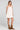 Side angle view of a woman wearing the Saltwater Luxe Lukas Mini Dress on a neutral background