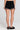 Back view of a woman wearing the Saltwater Luxe Lynden Black Short on a neutral background
