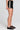 Side angle view of a woman wearing the Saltwater Luxe Lynden Black Short on a neutral background
