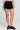 Front view of a woman wearing the Saltwater Luxe Lynden Black Short on a neutral background
