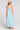 Back view of a woman wearing the Saltwater Luxe Marcelia Azure Blue Midi Dress on a neutral background