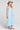 Side angle view of a woman wearing the Saltwater Luxe Marcelia Azure Blue Midi Dress on a neutral background