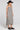Side angle view of a woman wearing the Saltwater Luxe Marcelia Black Midi Dress on a neutral background